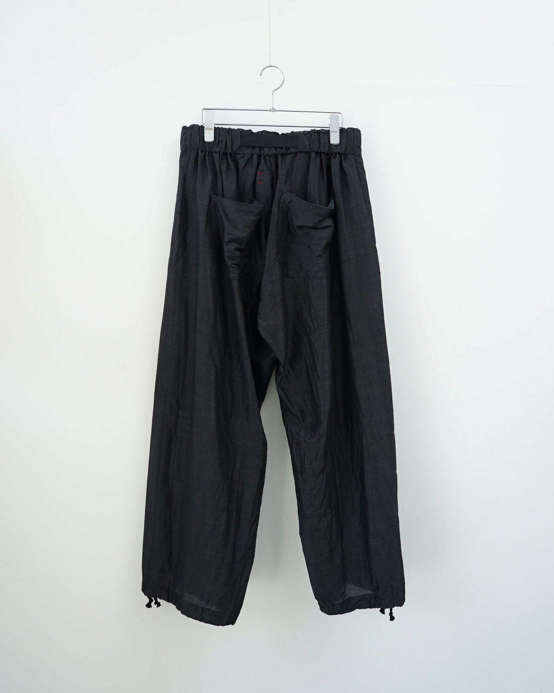 チャコールグレーのワイドタックパンツ。背面から見た全体像