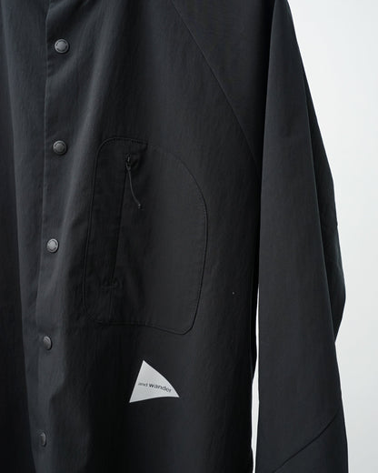 and wandar　fleece base band collar shirt（black）。胸のジップポケットとリフレクターロゴのアップ。