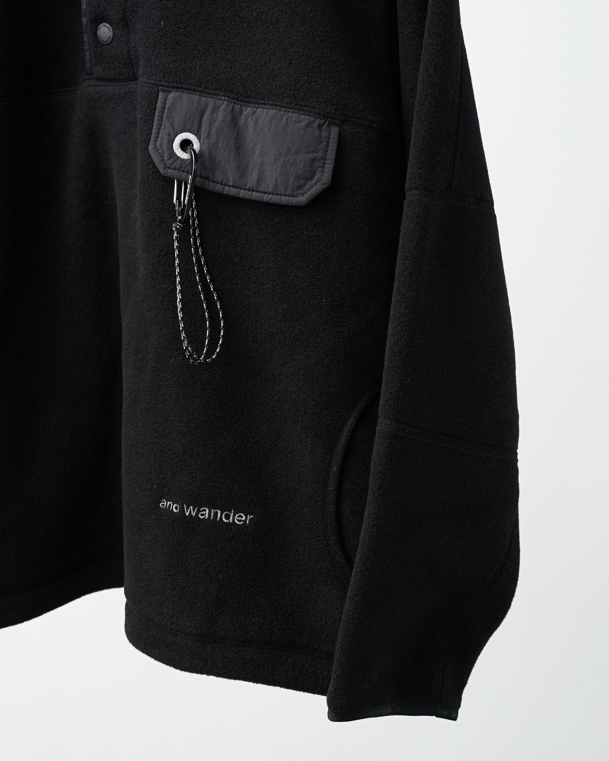 and wander wool fleece pullover (black)。胸のポケットとカラビナパーツ。