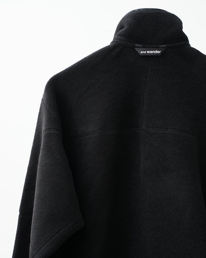 and wander wool fleece pullover (black)。襟元のブランドタグ。