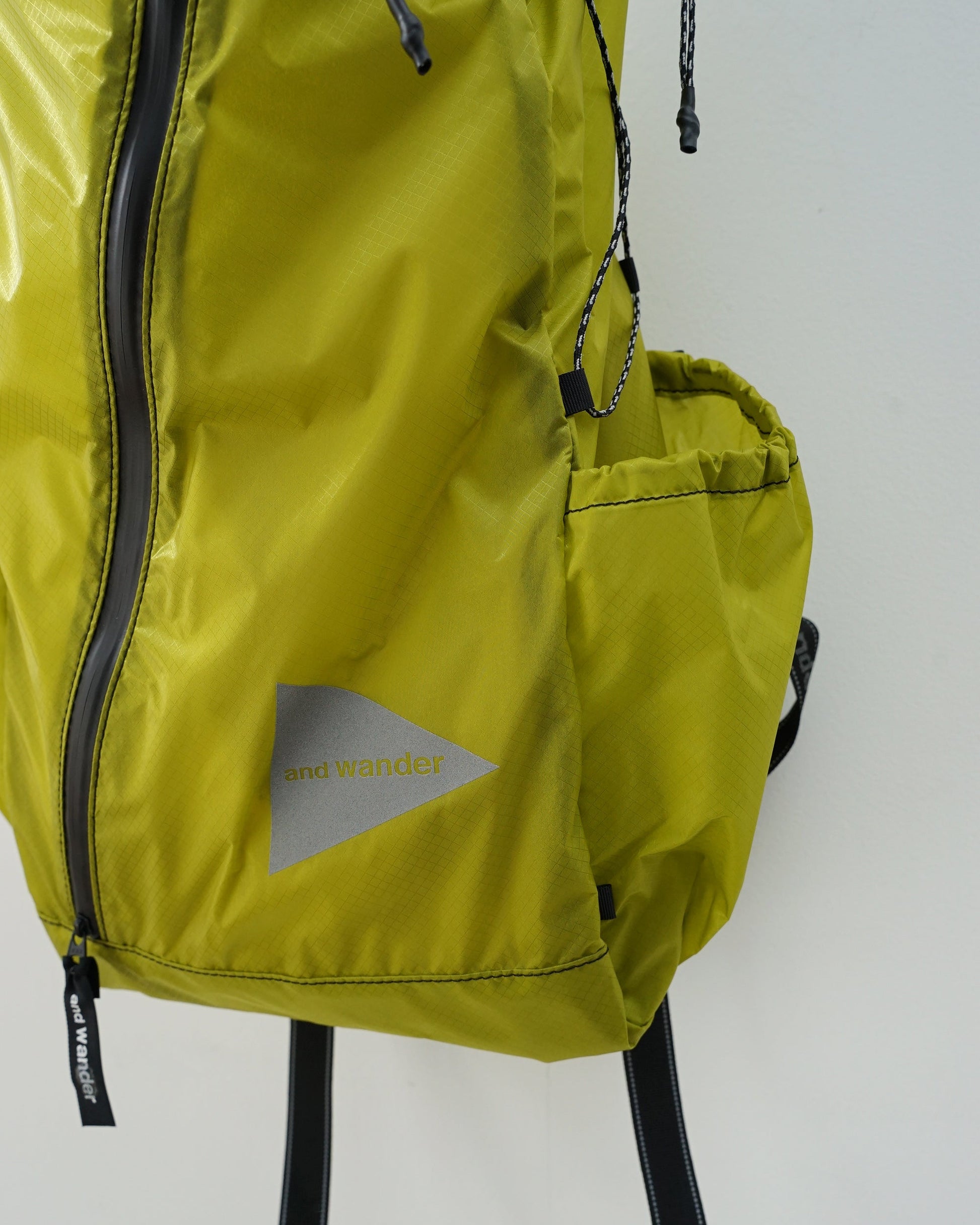 and wander アンドワンダー sil daypack 　バックパック　イエローグリーン　サイドポケット　ロゴ