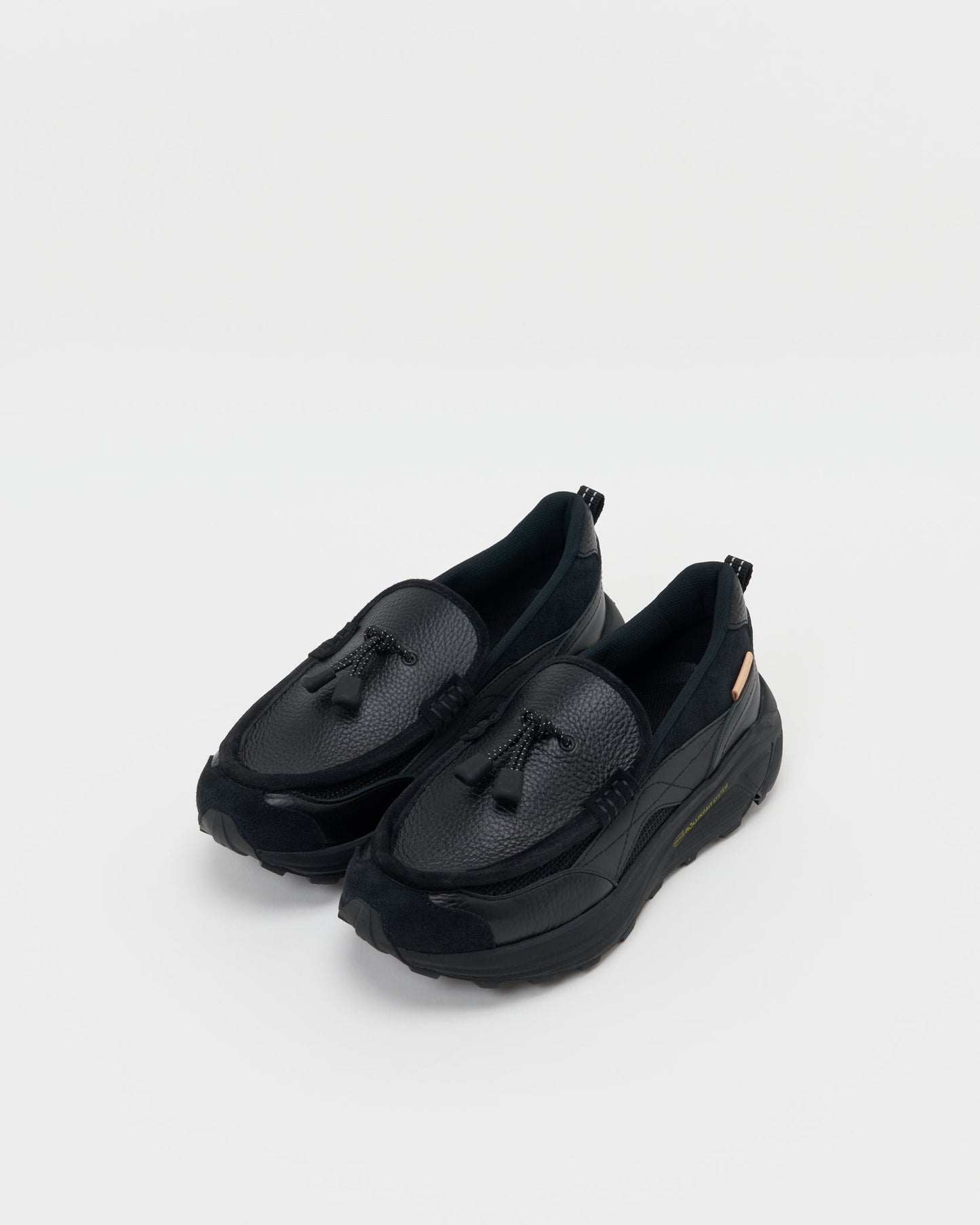 Hender Schemeのブラックローファー型スニーカー。斜めから見た全体像。