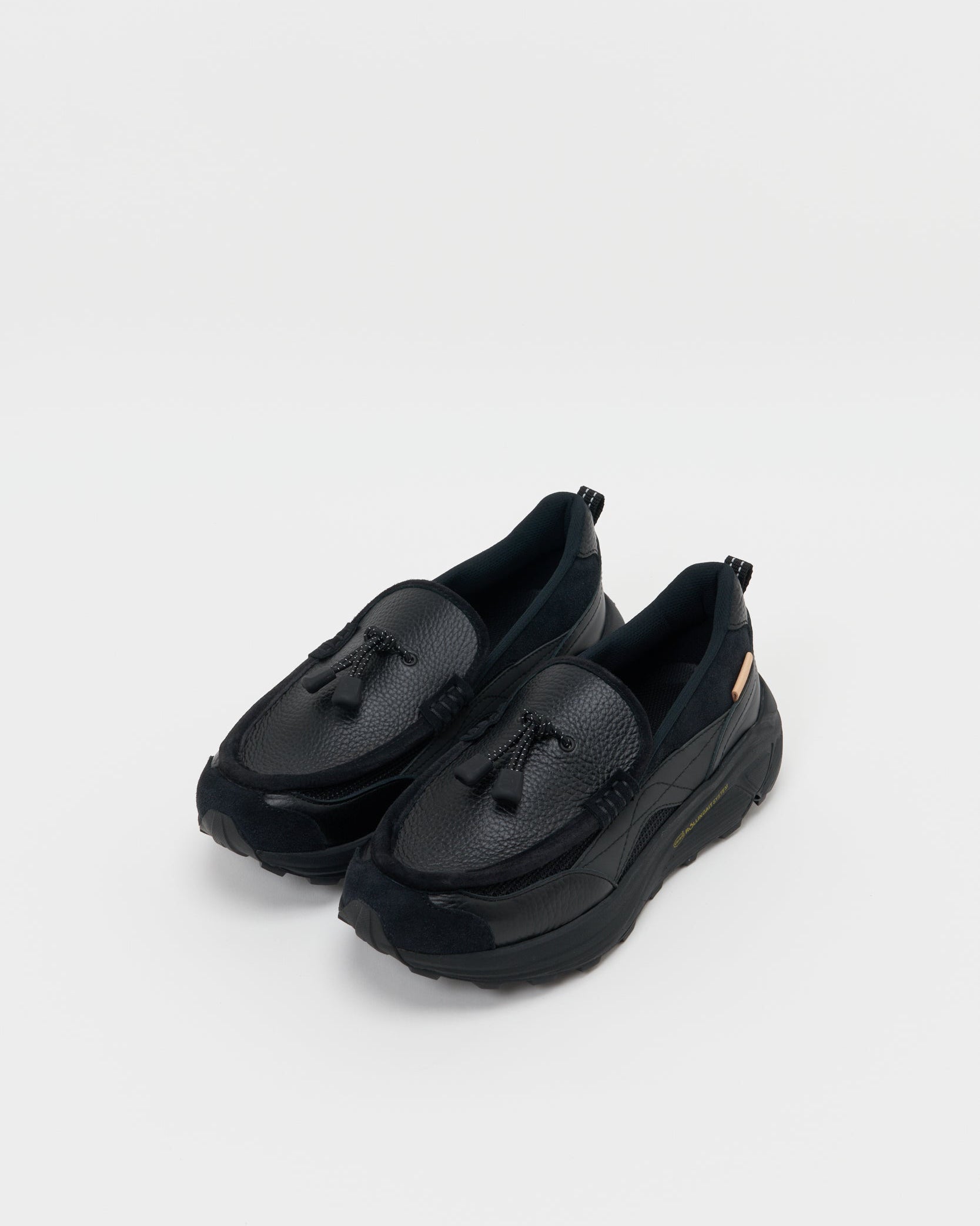 Hender Schemeのブラックローファー型スニーカー。斜めから見た全体像。
